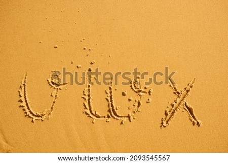 alphabet letters v w x handwritten in sand on beach