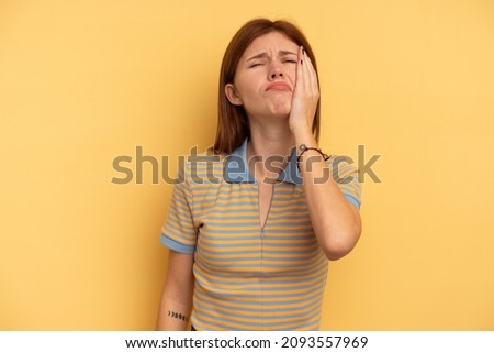 Young English woman isolated on yellow background tired and very sleepy keeping hand on head.