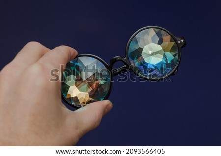 fashion designer glasses kaleidoscope in hand on blue background