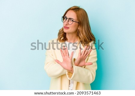 Young caucasian woman isolated on blue background doing a denial gesture Royalty-Free Stock Photo #2093571463
