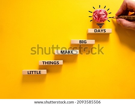 Little things make big days symbol. Wooden blocks with words Little things make big days. Beautiful yellow background, copy space. Businessman hand, light bulb. Business, motivational concept.