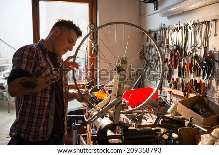 Young man working in a biking repair shop Royalty-Free Stock Photo #209358793