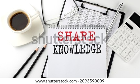 SHARE KNOWLEDGE text on paper with calculator, notepad, coffee ,pen with graph