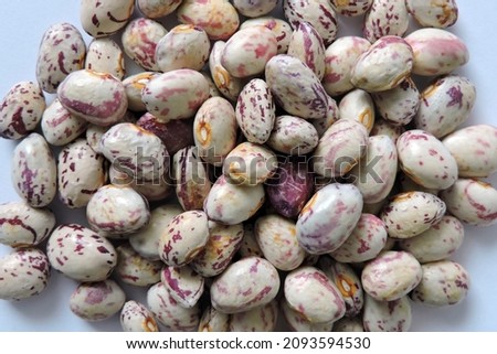 A pile of seeds of colorful dragon tongue beans, white background
