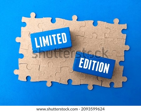 Selective focus.Jigsaw puzzle and colored block with text LIMITED EDITION on blue background.