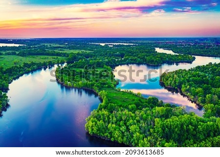 Rural summer sunset landscape with river and dramatic colorful sky, natural background, aerial view