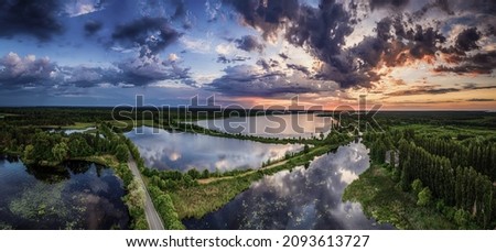 Rural summer sunset landscape with river and dramatic colorful sky, natural background, aerial panoramic view