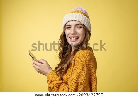 Profile shot entertained charming young woman playing mobile phone holding smartphone turning camera delighted having fun using cool app editing pics travel blogger messaging posting online