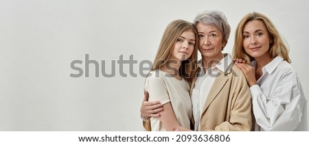 Caucasian family of three female generations hugging each other and looking at camera. Age and generation concept. Grandmother, mother and granddaughter. White background. Studio shoot. Copy space Royalty-Free Stock Photo #2093636806