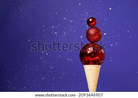 Christmas decoration red baubles in ice cream cone on veri peri magic background. winter New Year card
