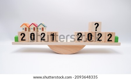 Scale comparing 2021 and 2022 housing market trends, question on real estate economics future plan and property value analysis. Business concept of forecasting financial effect from coronavirus crisis Royalty-Free Stock Photo #2093648335