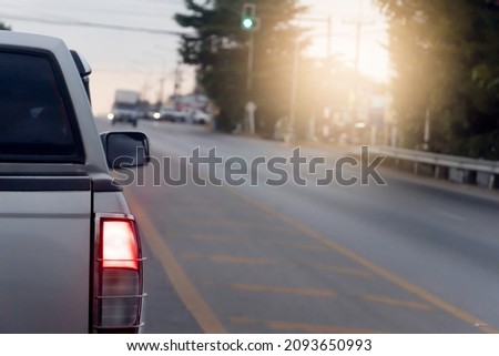 Back side of pick up car gray color on the asphalt road. With traffic conditions and hot sun during the day and other cars driving opposite lens. Royalty-Free Stock Photo #2093650993