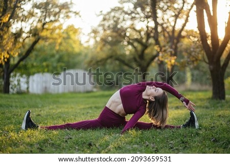 split-leg on the sunset, beautiful girl in sportswear doing yoga poses on the alley in the autumn park, balance, fitness, stretching and relaxation