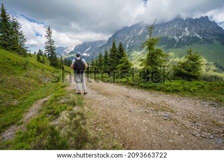 Traveler man on hiking trail enjoying Wilder Kaiser mountains, Tirol - Austria Royalty-Free Stock Photo #2093663722