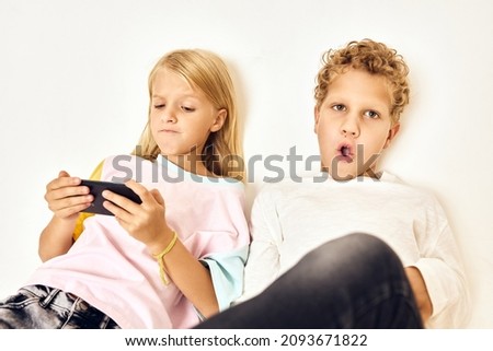 portrait of a boy and a girl phone playing together