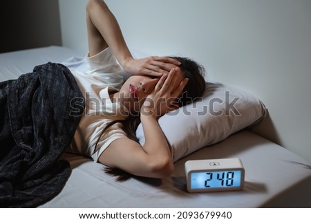 Asian women opened eyes lying on the bed have an insomnia problems. Royalty-Free Stock Photo #2093679940