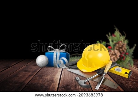 Construction hard hat and plumbing items with Christmas and New Year decoration over holiday background.