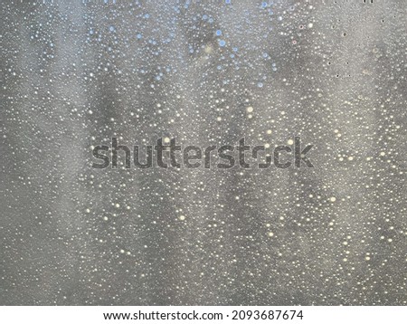 Blurred white bubbles from car glass window by using an automatic car washing machine