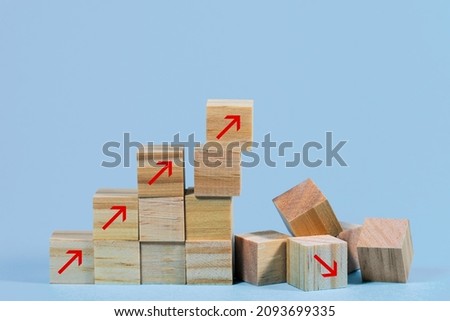 Collapsed stair structure of wooden cubes with upward pointing arrows, business risk due to inflation, crisis, supply shortage or unsustainable financial concept, blue background with copy space Royalty-Free Stock Photo #2093699335