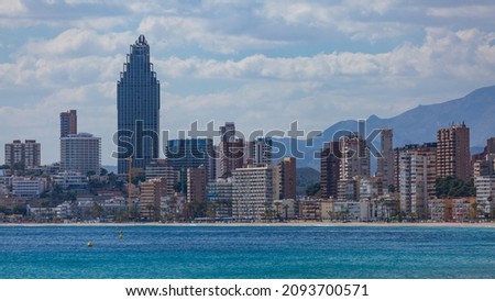 A modern city with high-rise buildings on the seashore. Sunny day on the city coast