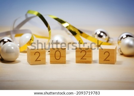 Wooden number cubes showing the new year 2022, Christmas decoration against a blue background, copy space, selected focus, narrow depth of field