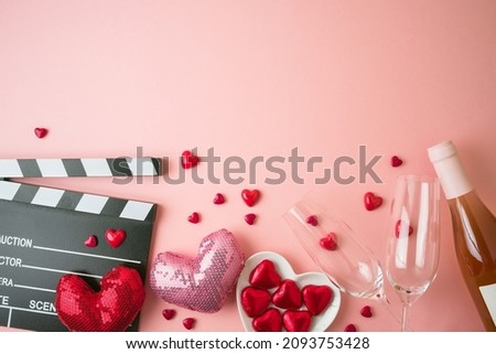Romantic movie border frame with movie clapper board, heart shapes and wine bottle on pink background. Valentines day concept. Flat lay, top view Royalty-Free Stock Photo #2093753428