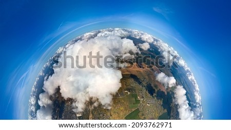 Aerial view from high altitude of little planet earth covered with white puffy cumulus clouds on sunny day Royalty-Free Stock Photo #2093762971