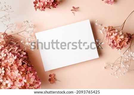 Wedding invitation or greeting card mockup with hydrangea and gypsophila flowers decorations. Blank card mockup on pink background. Royalty-Free Stock Photo #2093765425