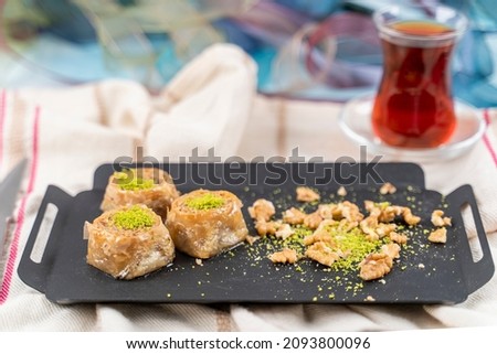 Traditional Turkish dessert called Bulbul Nest , Special baklava with walnut inside and pistachio powder on it, Sherbet dessert which is Turkish name is 'Bulbul Yuvasi' Royalty-Free Stock Photo #2093800096