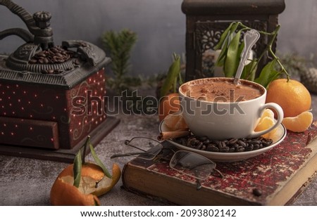 Close-up still life with a book, a geyser coffee maker, Christmas decor on the table. Selective focus.