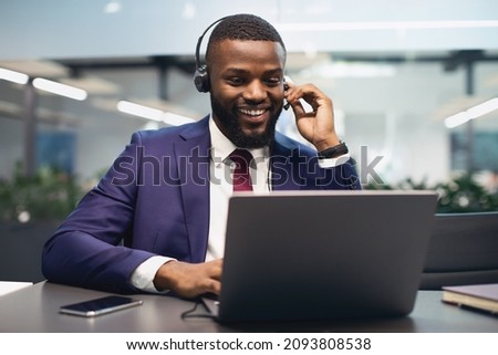 Cheerful african american manager having video call at office, using headset and modern laptop, attending online conference or having video chat with business partner, copy space Royalty-Free Stock Photo #2093808538