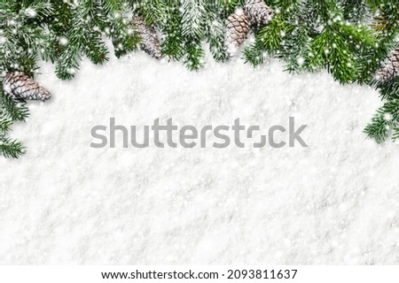 Christmas decorations on a snowy background. border with fir branches and cones.