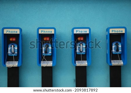 Payphones line a blue wall in Cayman Islands Royalty-Free Stock Photo #2093817892