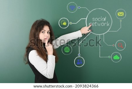 Pre-adolescent girl standing against social network chalk drawing on blackboard and pointing on it. High resolution photo. Full depth of field. Royalty-Free Stock Photo #2093824366