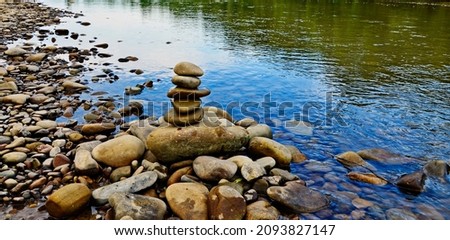 Close up of stacks of rocks on the river bank in a forest Royalty-Free Stock Photo #2093827147