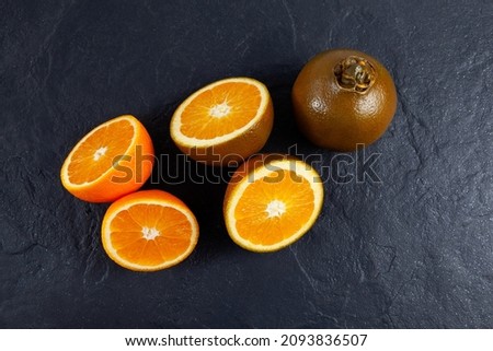 Navel Chocolate oranges, botanically classified as Citrus sinensis. Rare variety that belongs to the Rutaceae family. Oranges on dark stone background, top view. Royalty-Free Stock Photo #2093836507