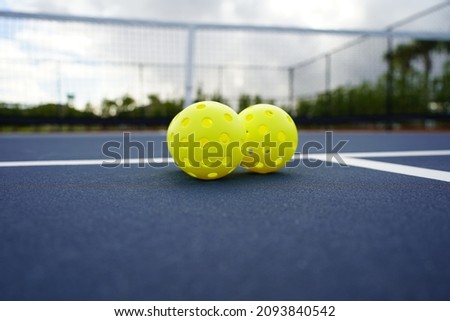 Close up of multiple pickleballs on pickleball court.                          Royalty-Free Stock Photo #2093840542