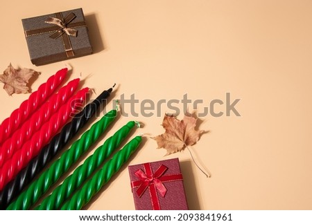 Kwanzaa African American celebration. Seven red, black and green candles on a natural beige background. Symbols of African heritage. Copy space