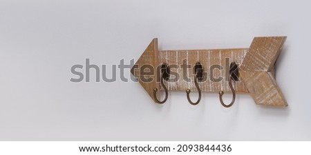 An arrow-shaped hanger for clothes or keys is located on the wall. copyspace for text