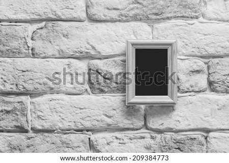 blank photo frame on old gray brick wall