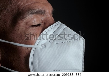 man praying to God with face mask on black background stock photo 