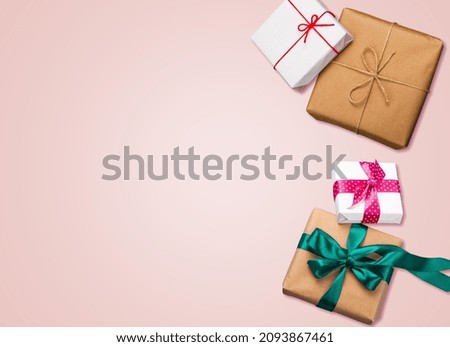 Gift boxes with bow and decor on pink background.