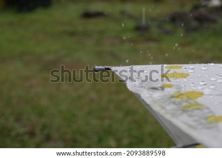 raindrops on a yellow polka dot umbrella.