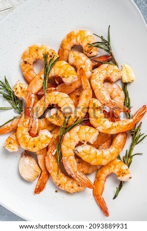 Fried Prawns Shrimps in a plate with herb and garlic. Gray background. Top view