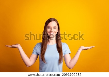 Photo of young cheerful girl hold hands solution promotion advertise isolated over yellow color background
