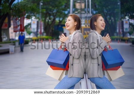 a beautiful girl standing in front of a boutique holding a shopping paper bag Portrait of a graceful young woman who enjoys shopping while shopping in the department store in the Sale season Copy spac