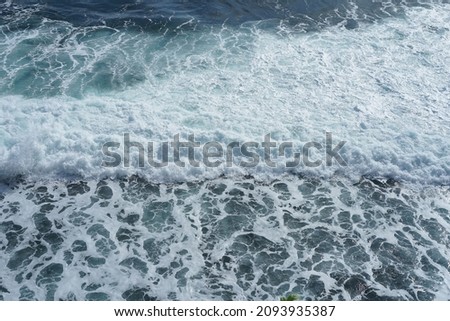 Waves crashing in the ocean, photographed from above