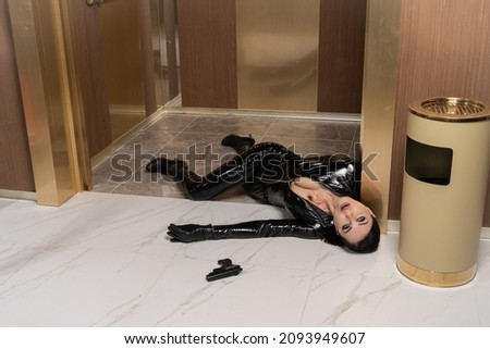 Hit woman. Woman in a latex suit killed in gunfire shot in the chest

 Royalty-Free Stock Photo #2093949607