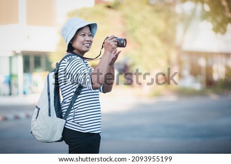 Asian woman taking picture photo with digital camera in city, Tourist asian female smiling using camera to take photograph on travel vintage piture style, lifestyle holiday travel on walk street.