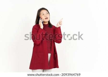 Talking on Smartphone and Pointing Aside Of Beautiful Asian Woman Wearing Red Shirt Isolated On White Background